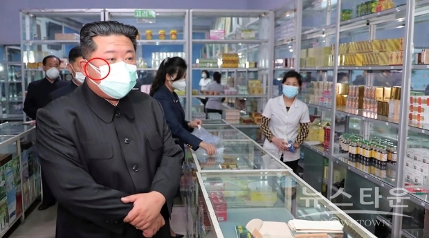 김정은 총비서의 마스크 오른쪽 끈(사진 붉은선 원)이 2개로 보여 얇은 덴탈 마스크 2개를 겹쳐 착용한  것이 보여, 북한의 마스크 등 의료 장비 및 도구들의 열악함을 보여주고 있다/ 사진 : 유튜브 캡처