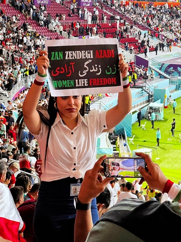 한 이란 축구팬이 카타르 월드컵 경기장에서 여성, 삶, 자유라는 글을 쓴 손피켓을 들어보이고 있다 / 사진 : 우키피디아