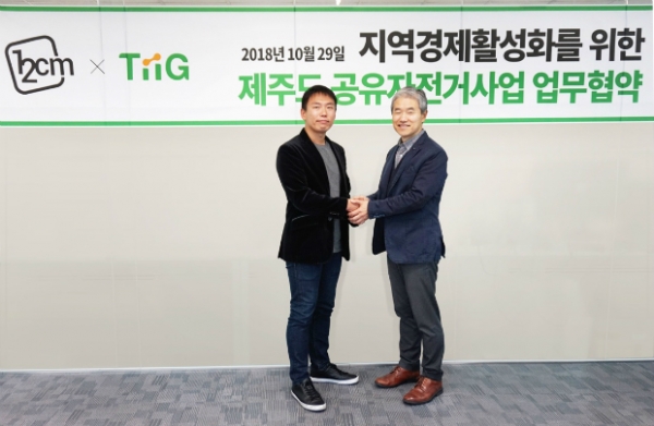 원투씨엠의 박근영 이사와 티그 이태현 대표가 업무협약을 체결하고 기념촬영 하고 있다