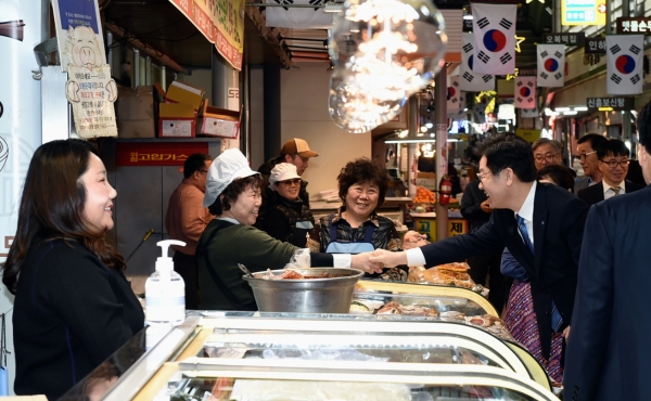 이재명 지사가 골목상권을 살피며 상인과 악수를 나누고 있다.