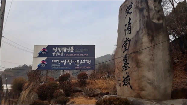쌍청회관이 들어서 있는 쌍청당묘역 입구에 쌍청웨딩홀과 문화체험 등을 알리는 간판이 시설돼 있다.