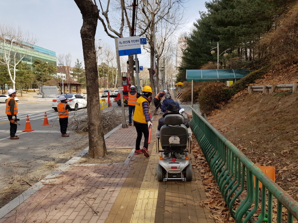 수원의 한 보도공사 현장에서 보행 안내를 하고 있는 보행안전도우미 모습.