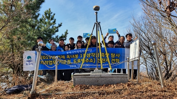 평택시 지적공무원 14인으로 구성된 지적역사조사단(3기)이 거제 옥녀봉(해발 약555m) 정상에 설치한 1등삼각점 관측 후 기념촬영을 하고 있다