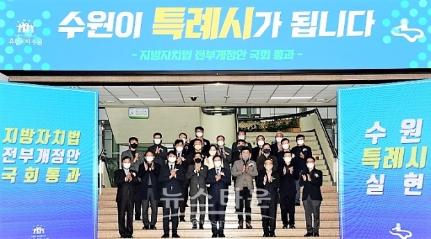 수원시청 로비에서 지방자치법 전부개정안 통과를 축하하며 염태영 수원시장과 수원시 직원들이 기념촬영을 하고 있다. /수원시