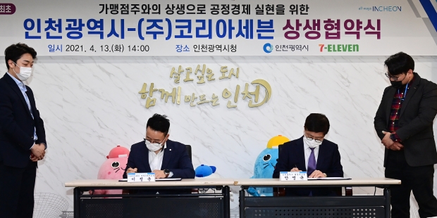 안영규 인천시 행정부시장, 이정윤 ㈜코리아세븐 경영지원부문장이 지난 13일 시청 대접견실에서 열린 '인천시-㈜코리아세븐 상생협약식'에서 협약서에 서명을 하고 있다.