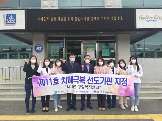 내남면 행정복지센터에서 치매극복 선도기관 지정 현판 수여행사 후 함께 기념촬영을 하는 모습