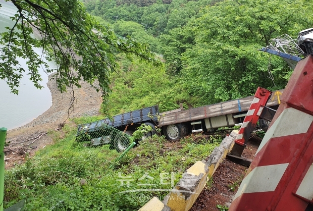 10일 오후 4시경 영천댐 25여m아래로 굴러떨어진 25t 화물 차량을 크레인 3대가 끌어 올리고 있다.