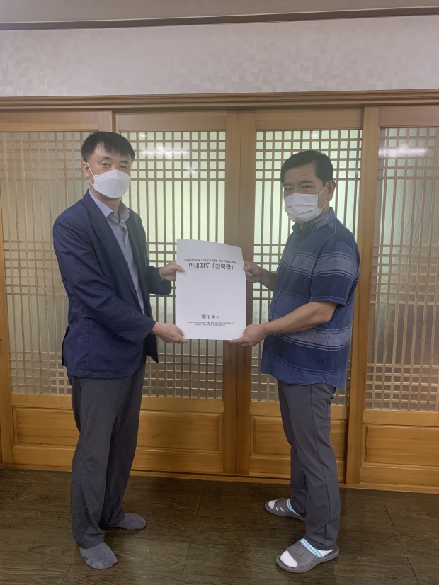 경주시 관계자가 최성환 천북면 신당2리 보증인에게 안내지도를 전달하고 있다
