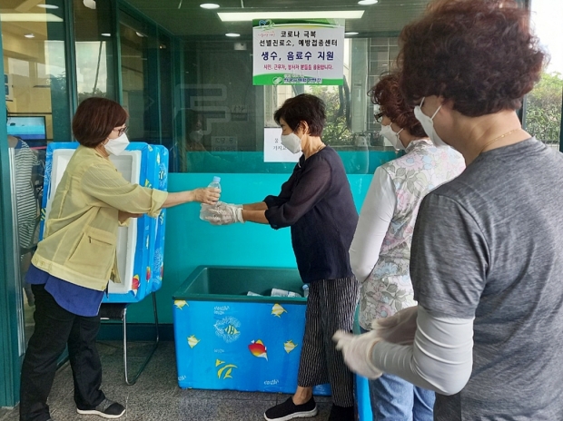 한수원이 경주시 예방접종센터와 선별진료소에 한달 간 생수 등 음료 2만7000개를 후원하기로 한 가운데, 22일 오전 경주시 예방접종센터 관계자가 시민들에게 한수원이 후원한 생수를 나눠주고 있다.