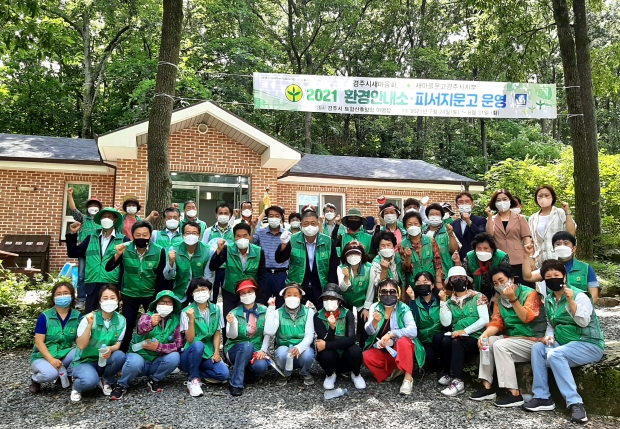 토함산휴양림 야영장에서 환경안내소, 피서지문고 개소식이 열리며 함께 사진 촬영을 하는 모습
