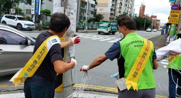 경주시와 경북옥외광고협회 경주시지부가 안전을 위협하는 불법광고물을 제거하고 있다