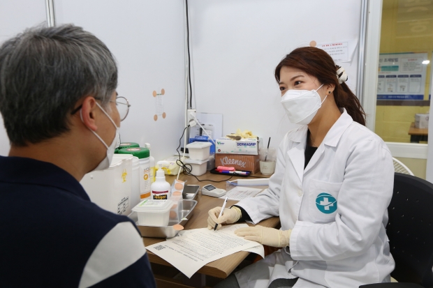 경주실내체육관에 마련된 코로나19 예방접종센터에서  한 시민이 백신을 맞기 전 주의사항을 듣고 있다.