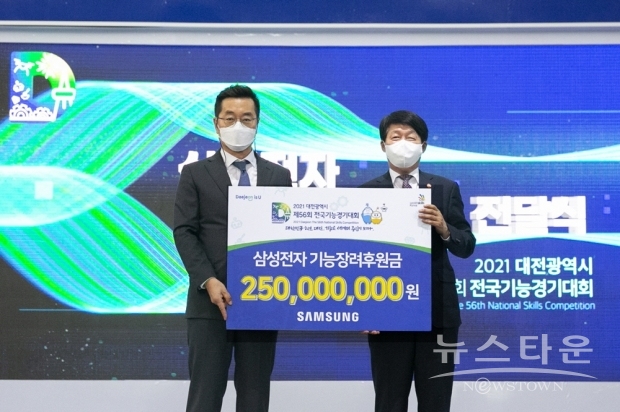 ▲ 5일 대전에 위치한 엑스포시민광장에서 열린 ‘제 56회 전국기능경기대회’ 개회식에서 삼성전자 장동섭 삼성기능올림픽 사무국장(왼쪽)이 안경덕 고용노동부 장관(오른쪽)에게 대회 후원금을 전달하고 있다.(사진 : 삼성전자)