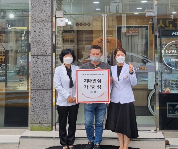 경주시 치매안심센터가 개인 사업장에 ‘치매안심가맹점’ 현판을 전달하며 기념촬영을 하고 있다