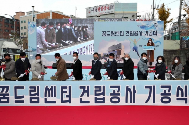 축포와 함께 꿈드림센터 건립공사 기공식에서 첫 삽을 뜨고 있는 허인환 구청장과 구청 및 동 관계자들의 기념 사진