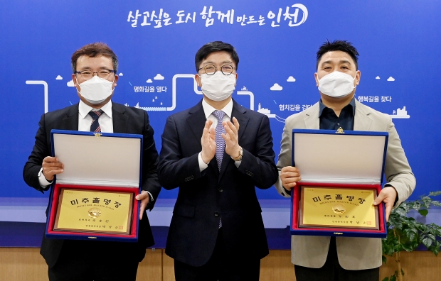 안영규 행정부시장이 지난 29일 시청 집무실에서 열린 '2021년 인천 미추홀명장 인증패·인증서 수여식'에서 조용진(표면처리), 강민호(제과·제빵) 명장에게 인증패를 수여하고 있다.