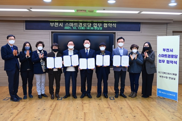 스마트경로당 업무 협약식 후 협약서를 들고 기념촬영을 하고 있다