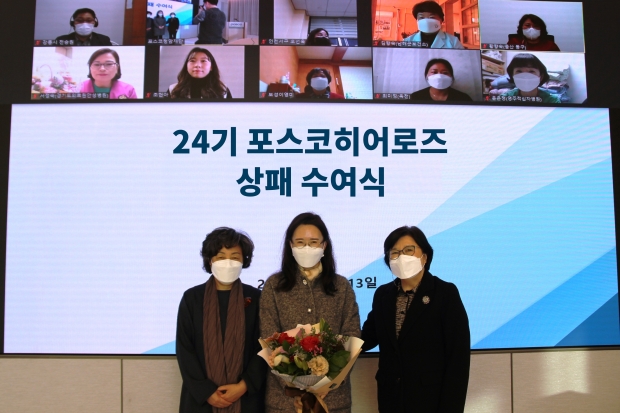포스코청암재단이 13일  포스코센터에서 코로나19 확산 방지를 위해 헌신한 포스코히어로즈 10명에게 상패와 장학금을 수여했다. 왼쪽부터 대한간호협회 신경림 회장, 한순욱 포스코히어로즈, 포스코청암재단 김선욱 이사장. 화면 상단에 온라인으로 참석한 9명의 포스코히어로즈