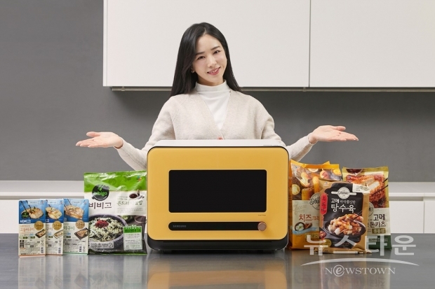 삼성전자 모델이 수원 영통구에 위치한 삼성전자 수원사업장에서 비스포크 큐커와 새롭게 협력하는 CJ의 다양한 간편식 제품을 소개하고 있다./사진 : 삼성전자