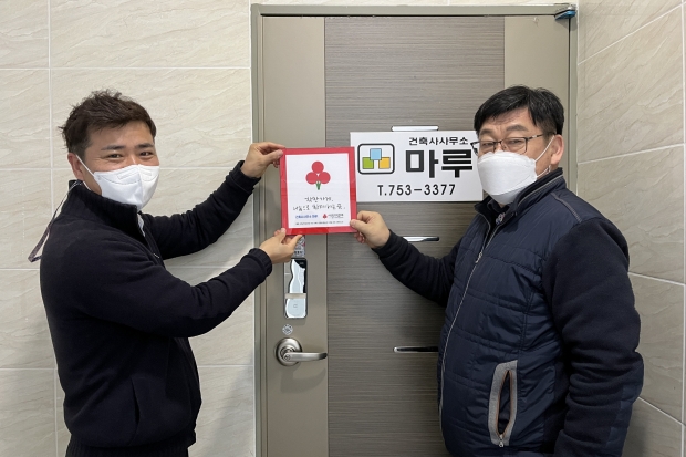 지난 15일 황성동 건축사사무소 마루 앞에서 착한가게 현판을 전달하고 있다