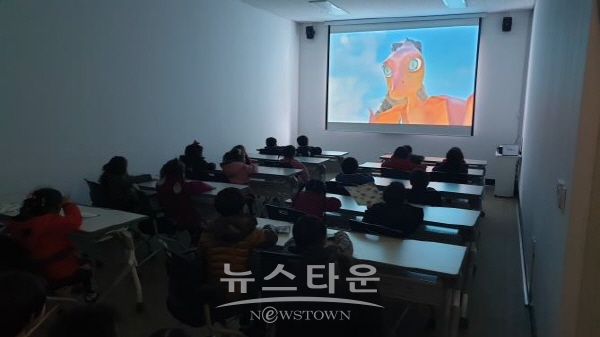 진주익룡발자국전시관 내 상영관에서 영상 시청 중인 유아들