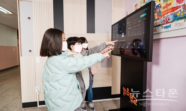 공기질 모니터링 시스템으로 실내 공기청정도를 확인하고 있는 보라매초등학교 학생들 /사진 : 한화그룹