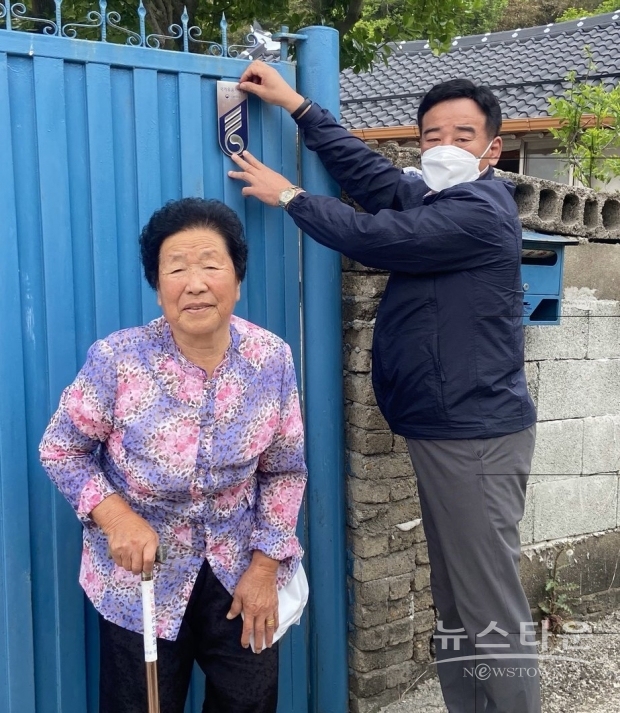 김영일 강진읍장이 국가유공자의 집 대문에 명패를 부착하고 있다. / 사진 : 강진읍