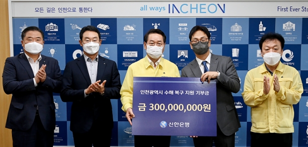 유정복 인천광역시장이 22일 시청 접견실에서 열린 '수해 복구 지원 기부금 전달식'에서 신한은행 박성현 부회장에게 기부금을 전달받고 있다.