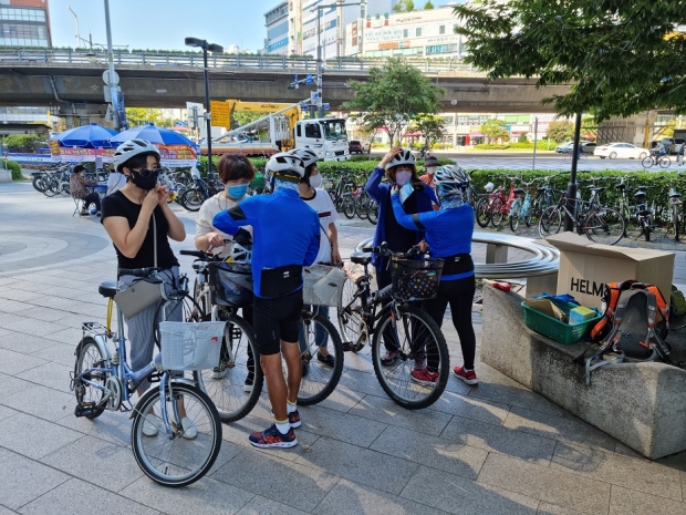 경찰관이 안전모 미착용 시민들에게 직접 안전모 착용과 야간 안전사고 예방 자전거 후미등 장착 서비스를 제공했다