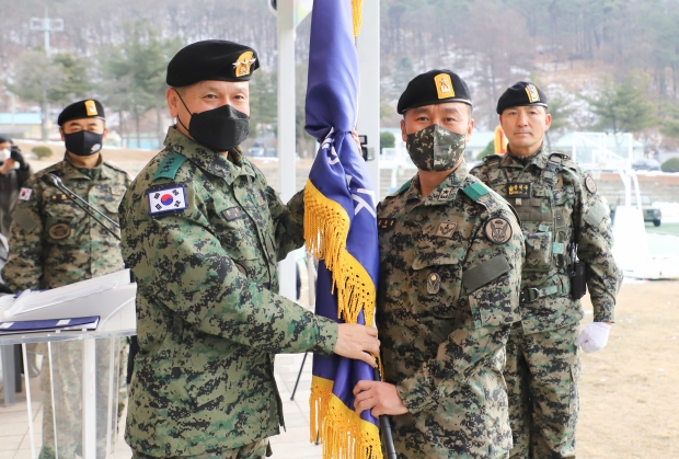 26일 제9공수특전여단 내 대연병장에서 손 식 특수전사령관(왼쪽)이 강부봉 신임 제9공수특전여단장에게 부대기를 전달하고 있다.