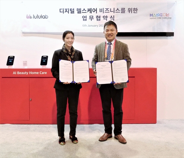 미국 라스베이거스에서 열린 CES 2023에서 업무협약식 체결한 천창기 한컴케어링크 대표(사진 오른쪽)와 모니카 박 (주)룰루랩 본부장이 기념촬영을 하고 있다