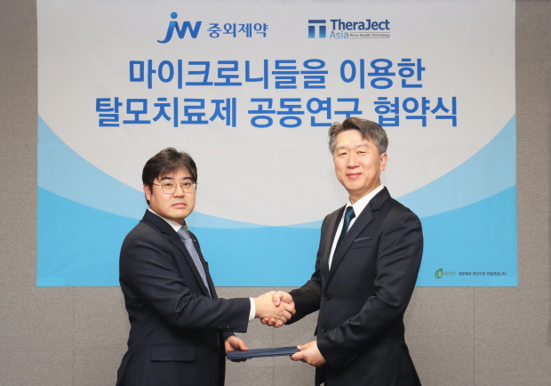 JW중외제약이 마이크로니들 연구기업 테라젝아시아와 마이크로니들 탈모치료제 공동연구 협약을 체결했다. 진세호 JW중외제약 제제연구센터장(왼쪽)과 김경동 테라젝아시아 대표이사가 협약을 체결한 뒤 기념사진을 촬영하고 있다.