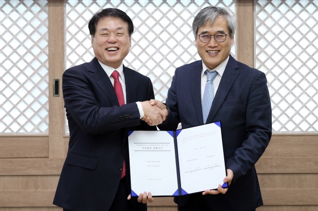 김진용 청장(오른쪽)이 백응섭 대표이사와 양해각서를 체결하고 악수하며 환하게 웃고 있다