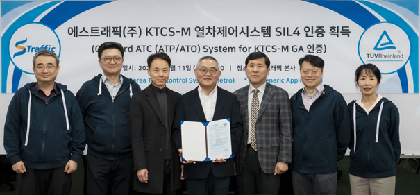 에스트래픽 이재현 사장(왼쪽에서 4번째)과 연구진 20여명이 참석한 가운데 TUV 라인란드 김영상 이사(왼쪽에서 5번째)로부터 SIL4인증서를 받고 있다.