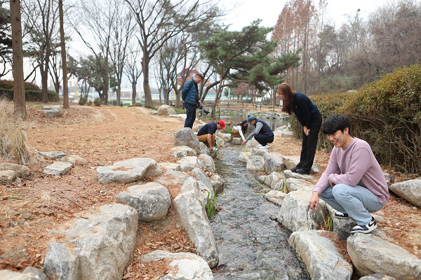 공단 직원들이 인천둘레길 9코스 주변에 개방한 실개천형 연못을 둘러보고 있다.
