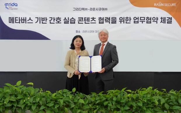 IT 보안•인증 플랫폼 기업 라온시큐어가 동작인식 실습 가상현실(VR) 플랫폼 전문기업 그리다텍과 ‘메타버스 기반 간호 실습 콘텐츠 협력을 위한 업무협약’을 체결했다. 윤원석 라온시큐어 화이트햇 센터장(사진 우측)과 옥지원 그리다텍 대표가 업무협약 체결 후 기념사진을 촬영하고 있다.