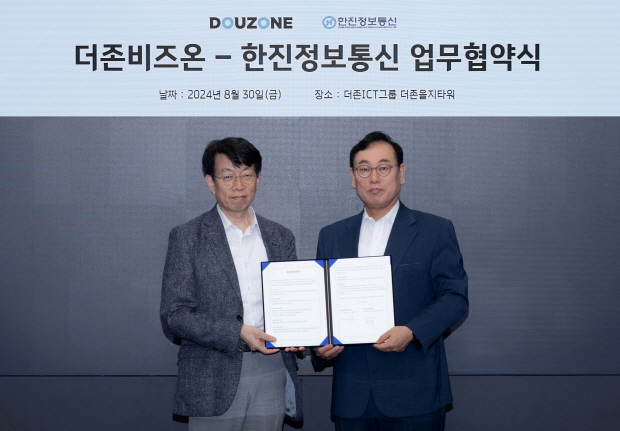 지난달 30일 서울 중구 더존을지타워에서 개최된 더존비즈온과 한진정보통신의 업무협약식에서 더존비즈온 이강수 사장(사진 오른쪽)과 한진정보통신 변봉섭 대표가 협약서를 교환하고 있다.