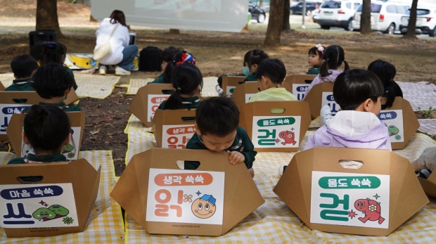 지난 7일 부평공원에서 열린 ‘읽·걷·쓰 이음 축제’에 참여한 아이들이 ‘읽기’ 체험장에서 동화 읽기를 기다리고 있다.
