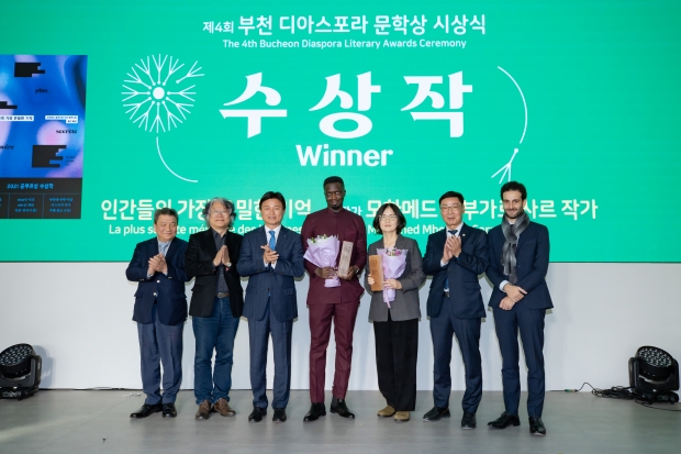 수상작을 집필한 사르 작가와 윤진 번역가(오른쪽에서 세번째)가 축하를 받고 있다.