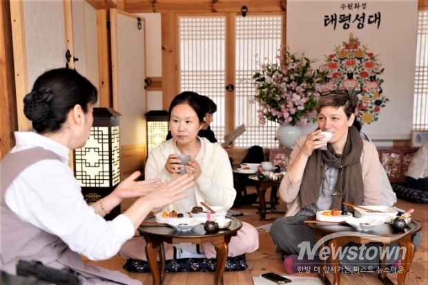 수원 화성행궁 별주에서 열리는 세계유산 활용 프로그램 ‘수원화성 태평성대’ 참가자들이 혜경궁 궁중 다과 체험을 하고 있다. /수원시<br>