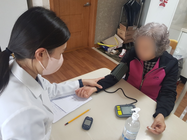통합건강돌봄센터 간호사가 어르신 혈압측정 하는 모습