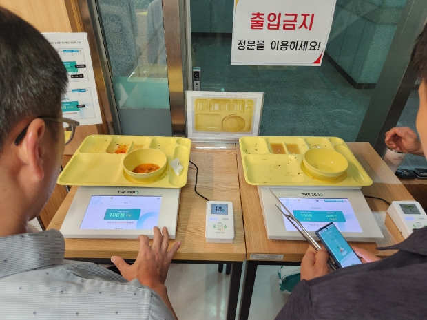 구내식당에서 식사 후 직원들이 잔반을 측정하고 있는 모습
