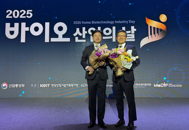 SK바이오사이언스 배정진 L HOUSE 운영지원실장(왼쪽)과 김창호 피플팀장이 산업통상자원부 장관 표창 수상 후 기념촬영을 하고 있다