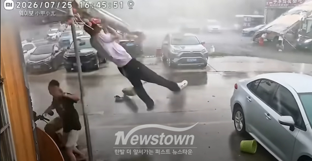 지난 26일 중국 광둥성에 상륙한 태풍 노을이 초속 45m 강풍을 동반, 상가 천막을 지키려던 주민이 천막과 함께 날아가는 모습/중국 웨이보 영상 캡처