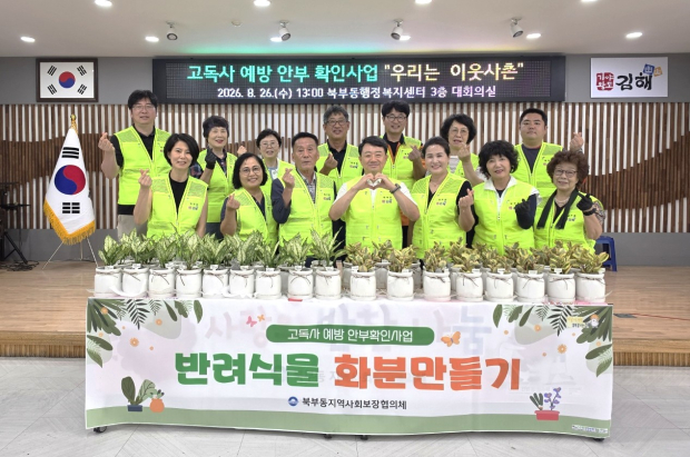 지난 26일 김해시 북부동 지역사회보장협의체 위원들이 고독사 예방 특화사업 ‘우리는 이웃사촌’을 통해 만든 반려식물 화분을 앞에 두고 기념촬영을 하고 있다./사진=김해시
