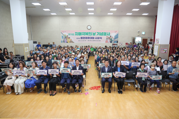 정영두 김해시장과 시민들이 8일 김해시동부노인종합복지관 대강당에서 열린 ‘제19회 치매극복의 날 기념행사’에서 치매환자와 가족을 응원하는 문구를 들고 기념촬영을 하고 있다./사진=김해시