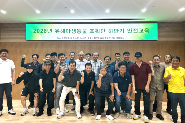 김해시 유해야생동물 포획단원들이 화포천습지과학관에서 하반기 안전교육을 받은 뒤 안전한 포획활동을 다짐하며 기념촬영을 하고 있다./사진=김해시
