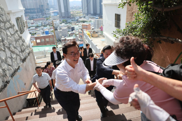 전재수 부산시장이 동구 산복도로의 좁고 가파른 계단을 올라 주민들과 인사를 하고 있다. (사진=부산시 제공)